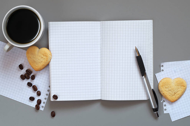 Відкритий блокнот і кава з пісочним печивом форма серця на сірому столі, вид зверху з пробілом для тексту
 - Фото, зображення