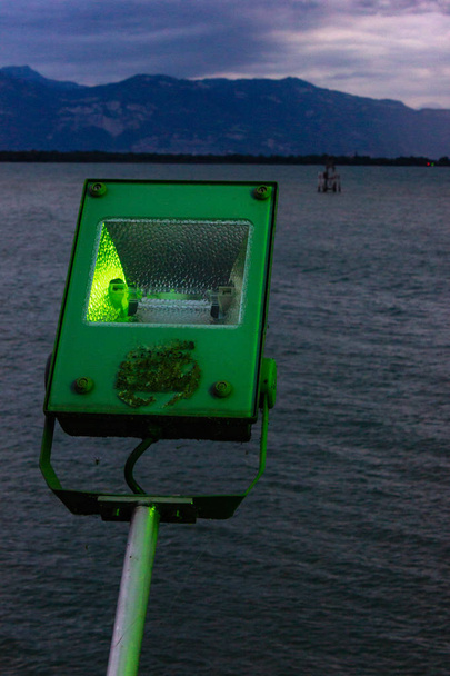 Zielona dioda led neon światło na łodzi pozostawiając portu w Lindau, Niemcy. - Zdjęcie, obraz