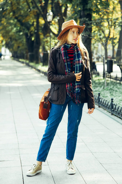 Meisje in stijlvolle herfst kleding wandelingen in het park. - Foto, afbeelding