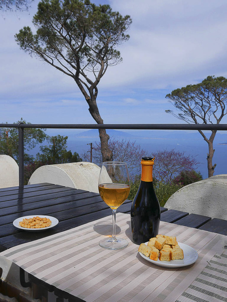 Стакан вина в саду виллы в Анакапри на острове Капри в Неаполитанском заливе на юге Италии
 - Фото, изображение