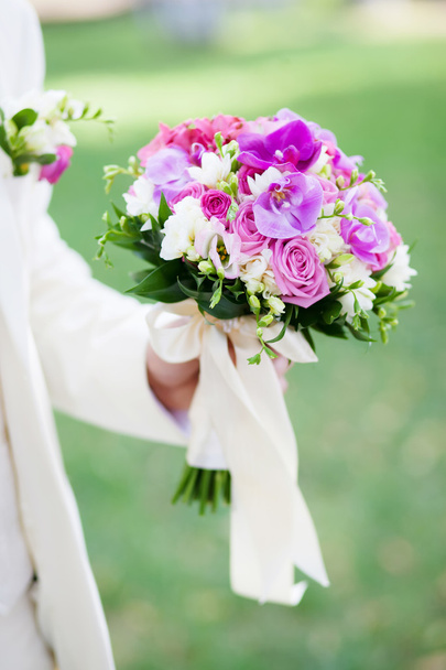 νεόνυμφου που κρατούν μια όμορφη γαμήλια ανθοδέσμη - Φωτογραφία, εικόνα
