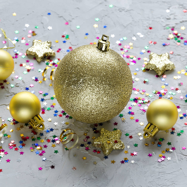 Christmas decoration. Golden Christmas toys and colorful stars on concrete background. Christmas background. - Фото, зображення