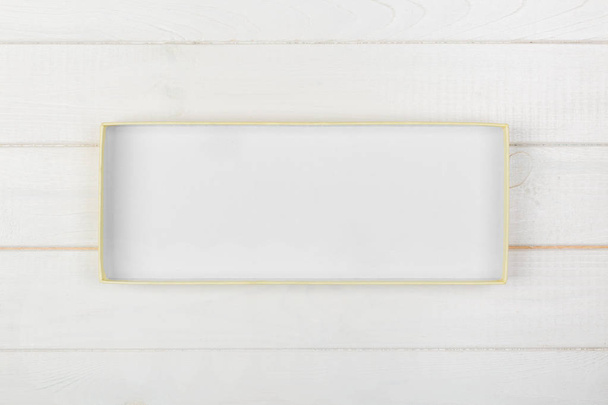 Boîte ouverte rectangulaire blanche vide, vue sur le dessus sur fond blanc en bois. vue de dessus
. - Photo, image