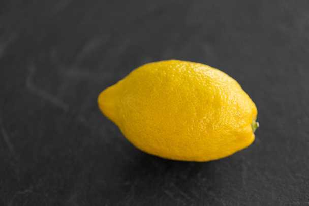 close up of whole lemon on slate table top - Foto, immagini