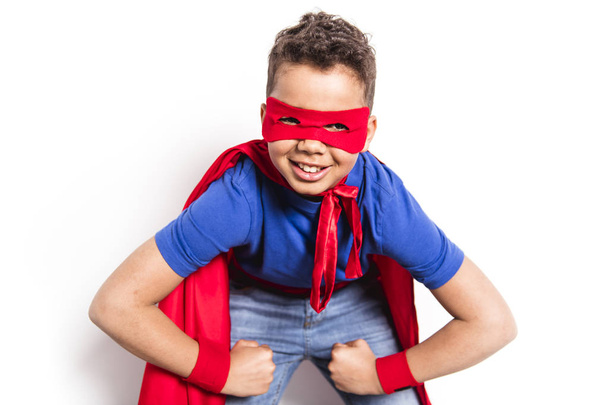 Portrait of boy in superhero costume against grey background - Foto, immagini