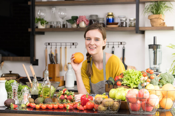 Genç kadında sağlıklı meyve ve sebzeler sağlıklı yemek ve salata için hazırlık bir mutfak - Fotoğraf, Görsel