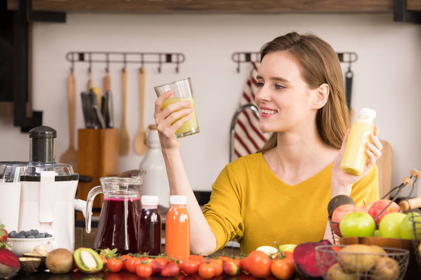 Jeune femme en bonne santé dans une cuisine avec des fruits et légumes et jus
 - Photo, image