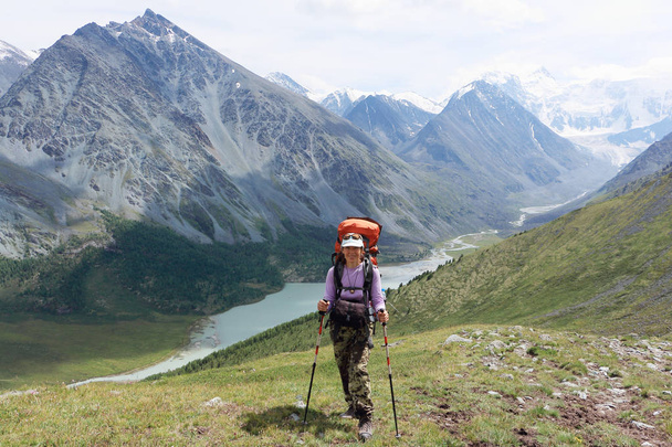 Tourist woman standing on Pass Kara-Turek against the Belukha Mountain and Akkem Lake, Altai, Russia - Foto, Imagen
