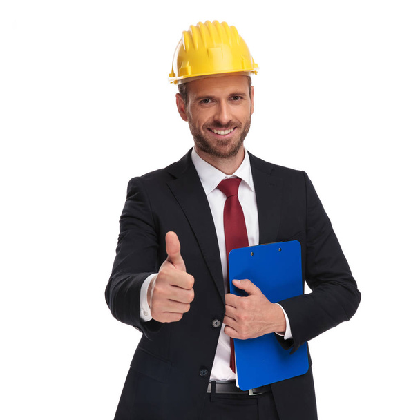 portrait of engineer boss with blue folder making ok sign while standing on white background - Photo, Image