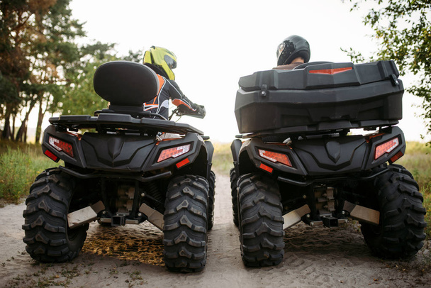 Due motociclisti in casco, vista posteriore. Freeride in quad, sport estremi e viaggi, avventura estiva quadbike
 - Foto, immagini