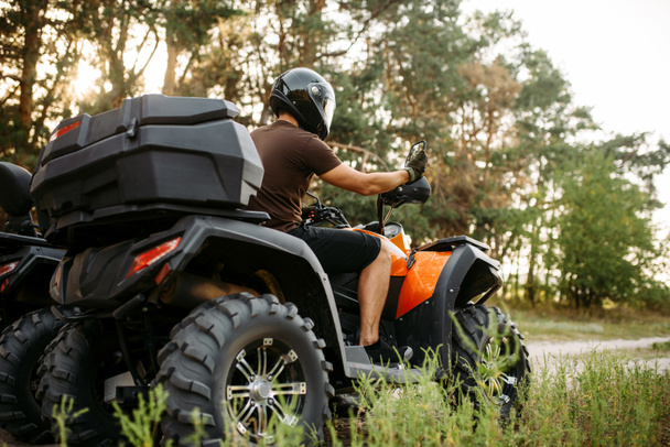 Rider in helmet and equipment on quad bike, front view, closeup. Male quadbike driver, atv riding - Photo, Image