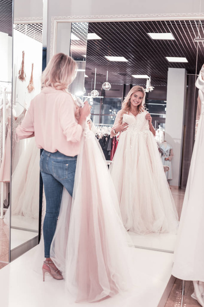 Joyful delighted woman looking at the wedding dress - Photo, image