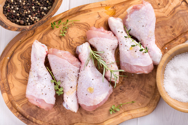 Raw chicken drumsticks on cutting board. Uncooked chicken legs. Top view. - Photo, Image