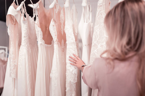 Close up of beautiful wedding dresses on hangers - Фото, изображение