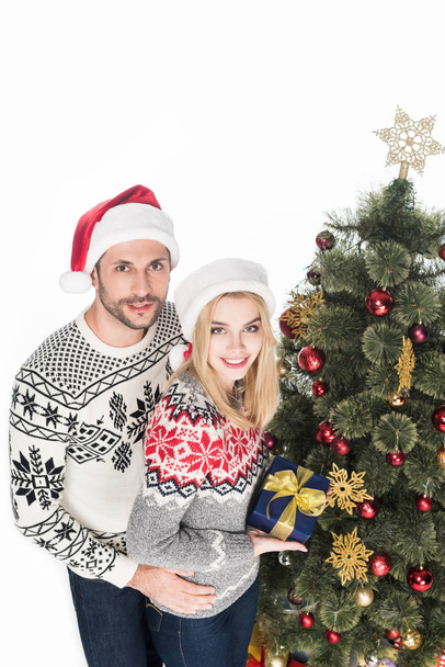 high angle view of couple with wrapped gift near christmas tree isolated on white - Foto, Imagem