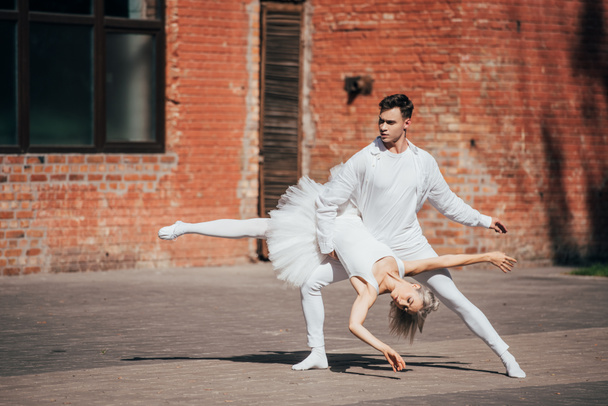 beautiful young ballet dancers performing on urban city street   - 写真・画像