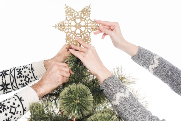 cropped shot of couple decorating christmas tree together isolated on white - Foto, imagen