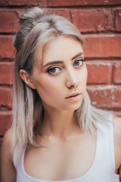 portrait of beautiful blonde girl looking at camera on street  - Photo, Image