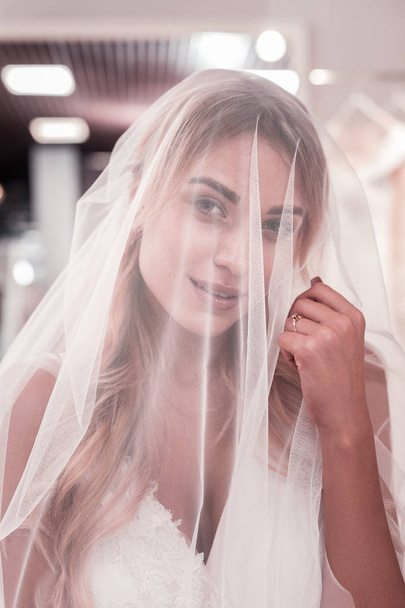 Pleasant nice young woman touching her veil - Foto, Imagem