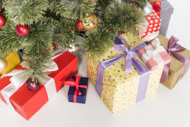 close up view of wrapped presents under christmas tree isolated on white - Photo, image