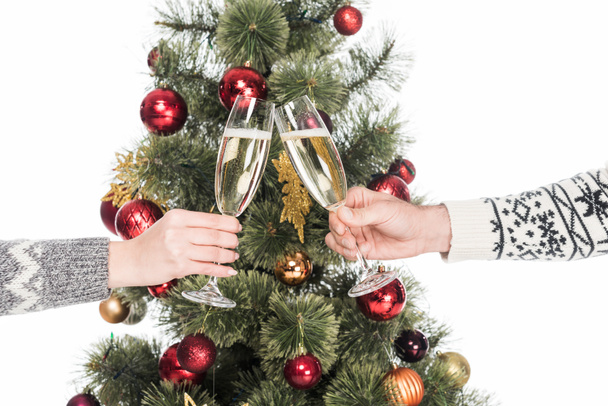 recortado tiro de par tintineo copas de champán con árbol de Navidad en el fondo aislado en blanco
 - Foto, imagen