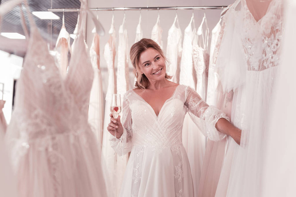 Happy positive woman looking at the wedding dresses - Foto, Imagem