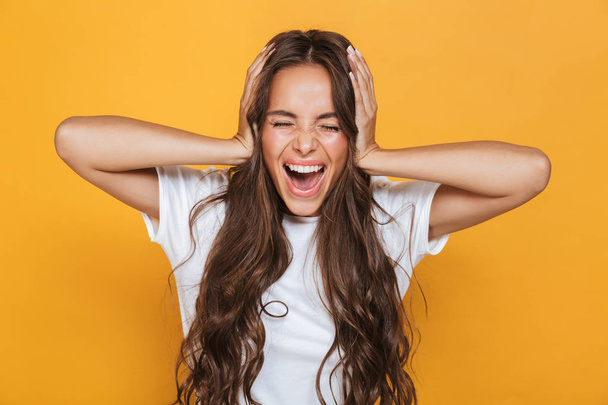 Image of screaming emotional young woman isolated over yellow background. - Φωτογραφία, εικόνα