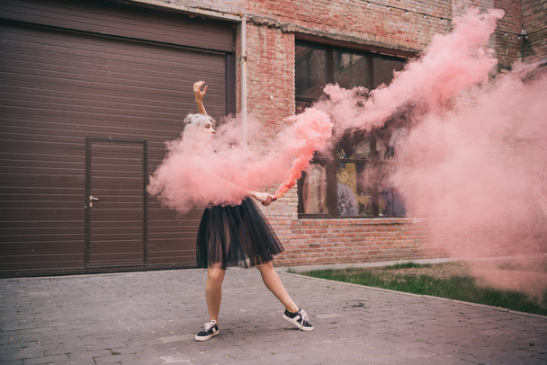 attractive girl dancing in pink smoke on street  - Fotoğraf, Görsel
