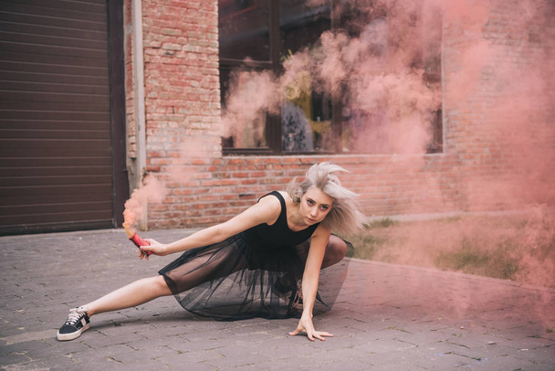 beautiful young female dancer in pink smoke on street - Photo, Image