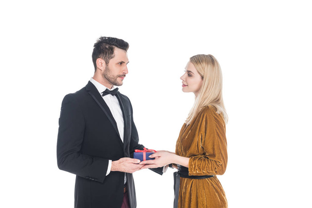 jeune homme présentant cadeau enveloppé à belle petite amie isolée sur blanc
 - Photo, image