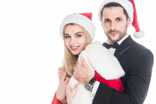 young man putting santa claus costume on girlfriend isolated on white - Fotoğraf, Görsel