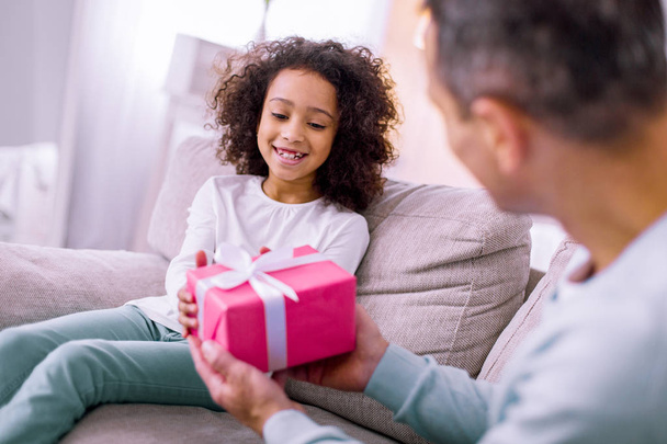 Cheerful girl taking present from her father - Photo, Image