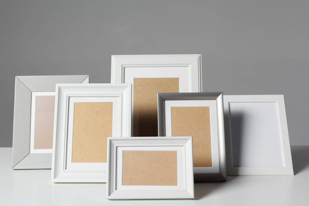 Different empty photo frames on table - Foto, Imagem