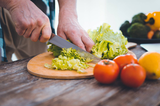 Close up of lettuce being cut on the cutting board - Fotoğraf, Görsel