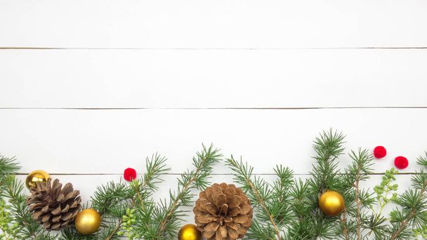 Kreatív karácsonyi elrendezés. Fenyő gallyak, pinecones és arany golyó. Fehér fa háttér fikarcnyi másol hely. Szegély elrendezése. Lapos laikus felülnézet.  - Fotó, kép