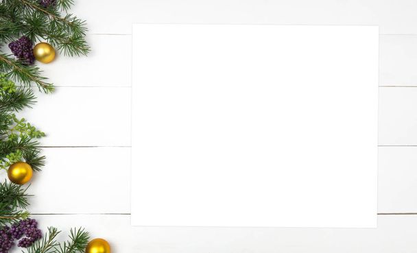 Creative Christmas layout. Fir twigs and golden balls. White wood background whit copy space. Border arrangement. Flat lay top view.  - Photo, Image