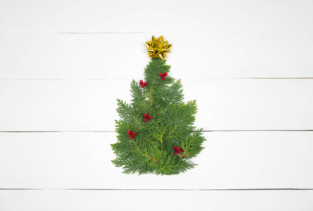 Kreative Weihnachtsgestaltung. Weihnachtsbaum auf weißem Holz Hintergrund. flache Lageoberseite.  - Foto, Bild