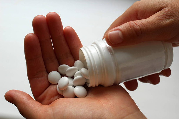 pills medication with packaging on hand for oral administration - Foto, Imagen