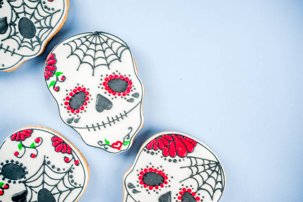 Dia de Los Muertos, Mexicaanse dag van de doden of Halloween groet kaart achtergrond met traditionele kleurrijke schedel vormige cookies met suiker topping snoepjes bovenaanzicht kopiëren ruimte - Foto, afbeelding