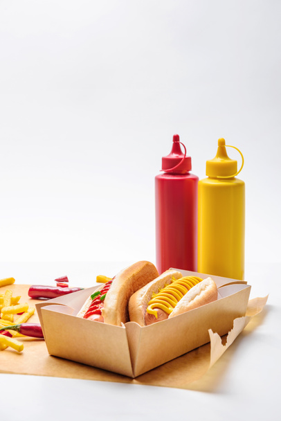 close-up shot of delicious hot dogs with french fries on paper and on white - Photo, Image