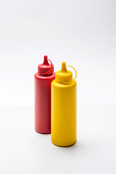close-up de garrafas de ketchup e mostarda em mesa branca
 - Foto, Imagem