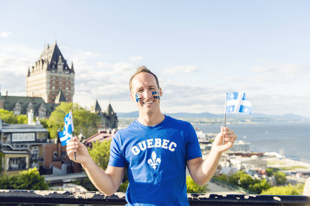 man celebrates the national holiday in front of Chateau Frontenac in quebec city - Fotó, kép