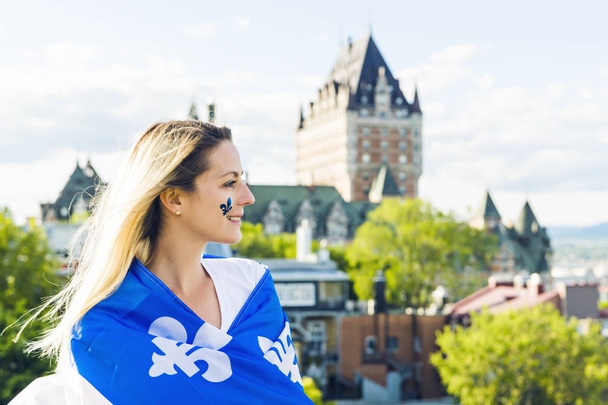 Woman celebrates the national holiday in front of Chateau Frontenac in quebec city - Fotó, kép