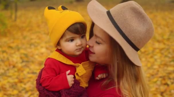 Alkalmi interracial család. Csípő anya és szórakozás az őszi parkban vegyes faj gyermeke. - Felvétel, videó