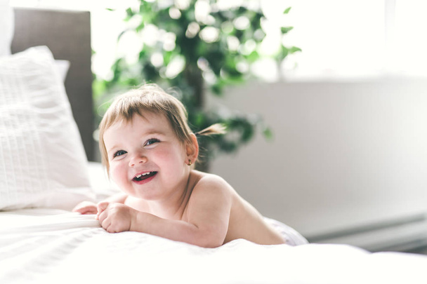 un bébé fille ans sur le côté du lit
 - Photo, image