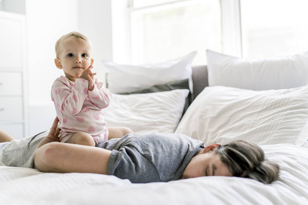tired father with baby lying on bed at home - Foto, immagini