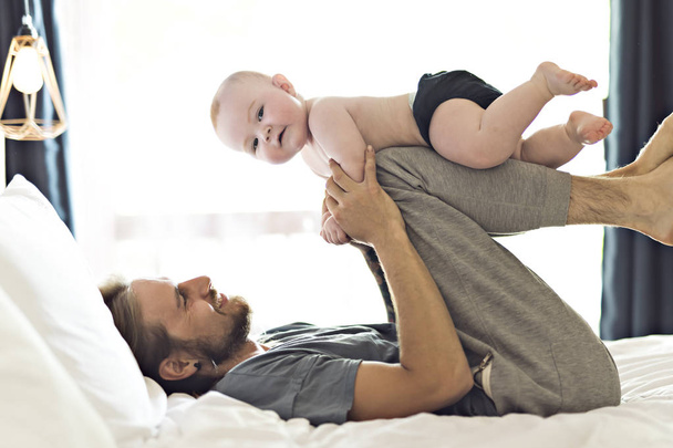 Father playing with adorable baby girl in bedroom - Foto, Imagem