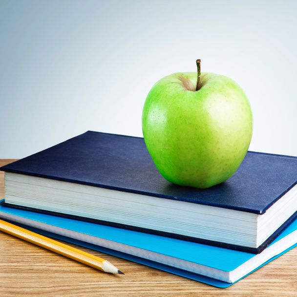 Book, notebook with apples and pencil on table - 写真・画像