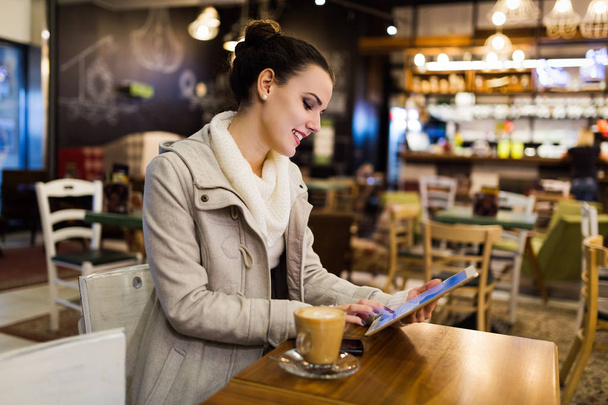 Attractive young woman using digital tablet in cafe - Valokuva, kuva