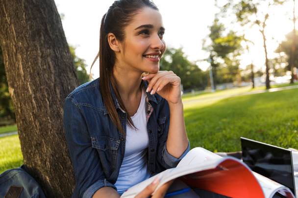 Image of amazing beautiful young woman student in the park holding copybook. - Φωτογραφία, εικόνα